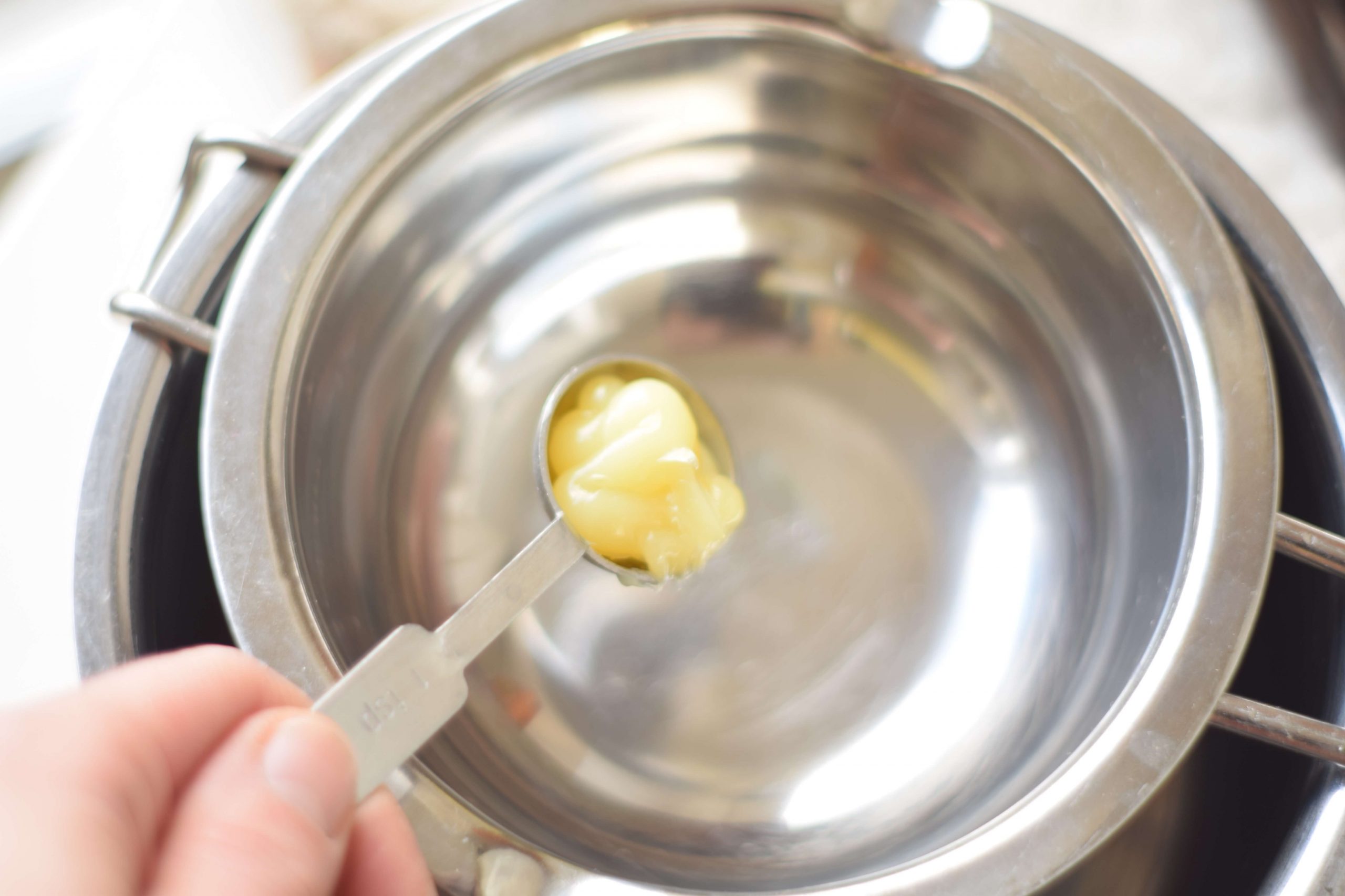 Melting a teaspoon of lanolin in a double boiler