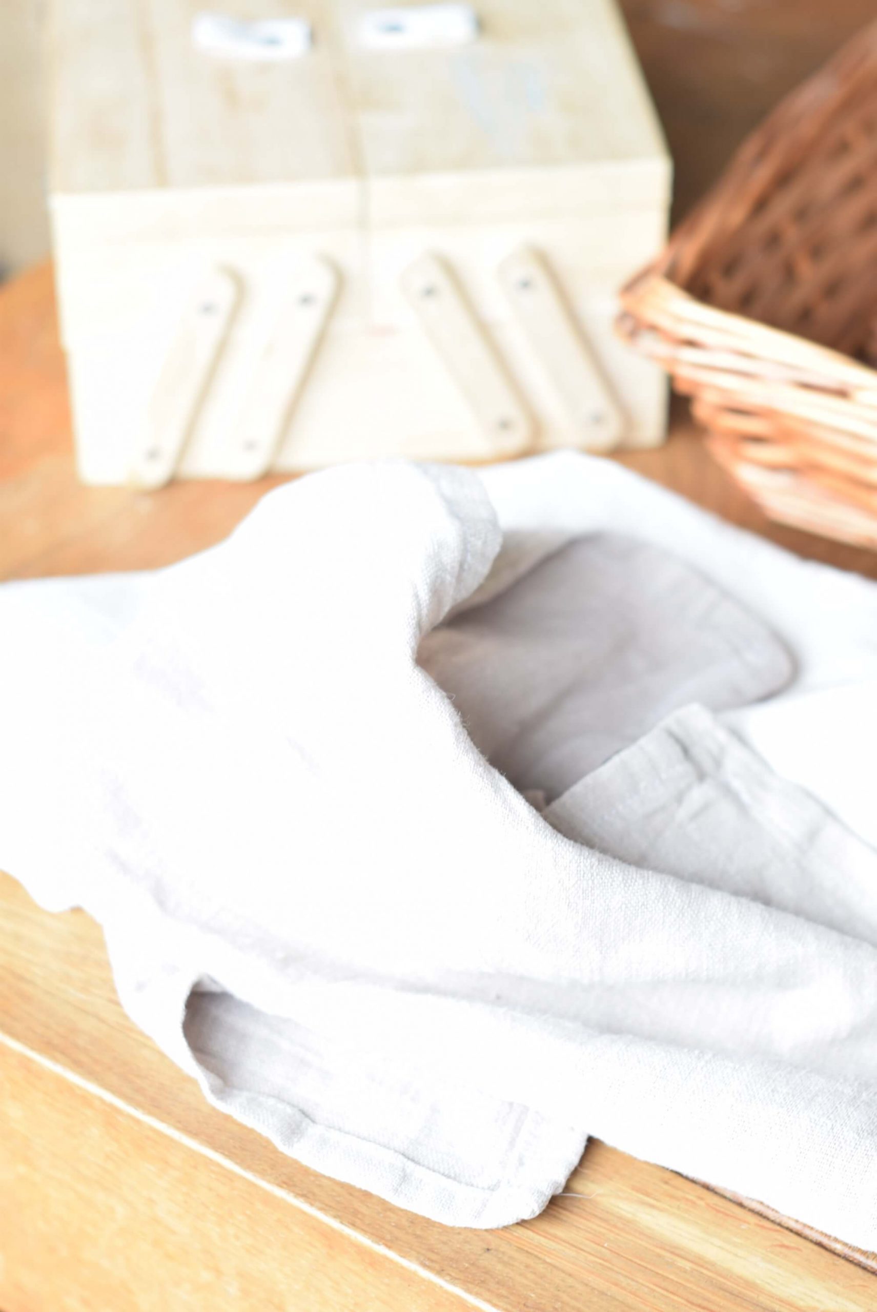 Image of linen fabric and sewing box on wooden table