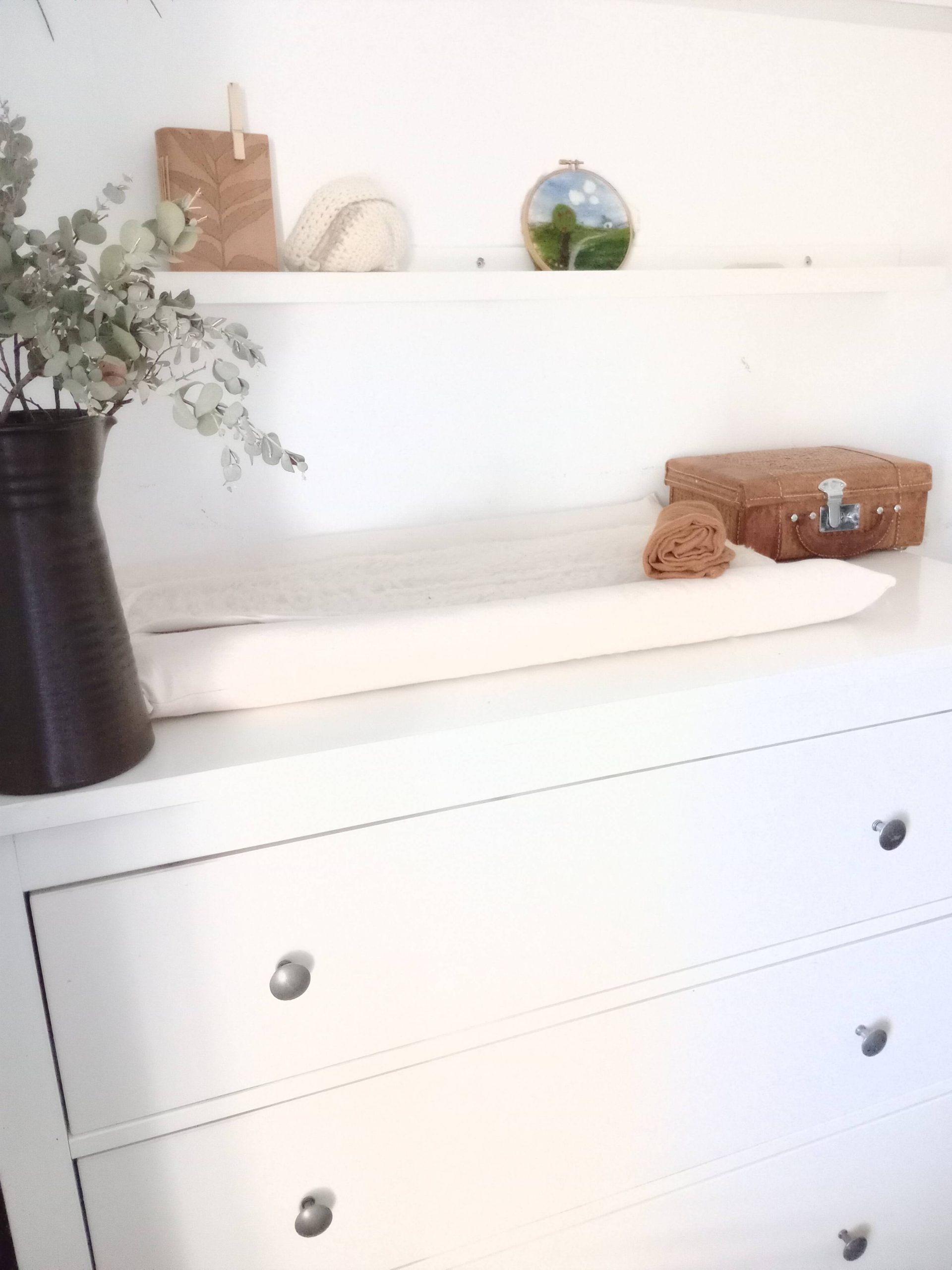 An eco-friendly wool changing pad on a white changing table.