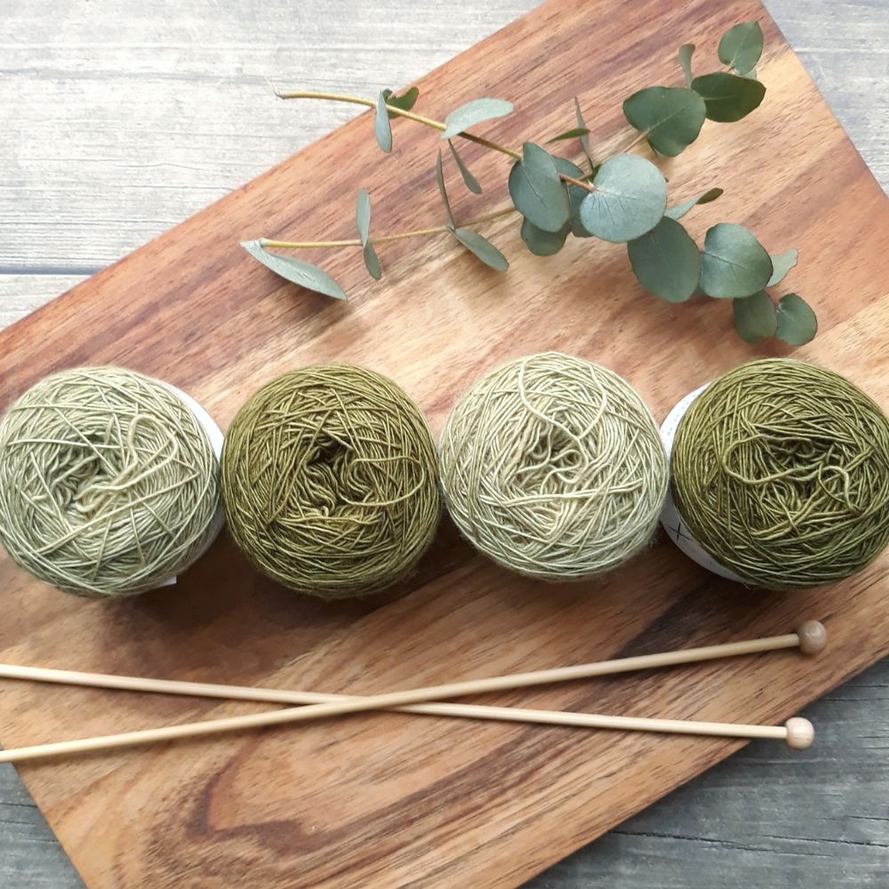 A wooden cutting board displays vibrant yarn balls and knitting needles, inviting creativity in knitting and crafting. Finding new hobbies as a homemaker.