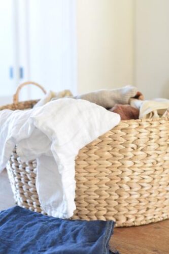 Basket full of fresh laundry on a wooden table