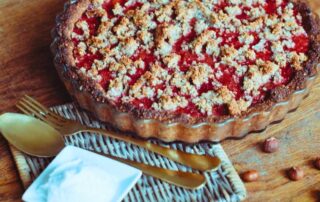 Strawberry gooseberry pie recipe with a golden fork, spoon, and a generous dollop of coconut cream for topping.